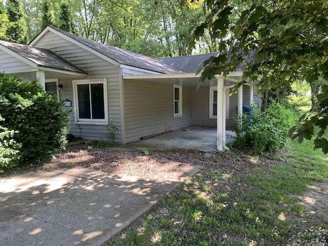 1316 N Factory St, Fairmount, IN 46928 - view of side of home with roof with shingles, a carport, and a patio