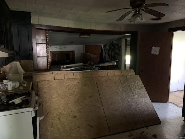 1316 N Factory St, Fairmount, IN 46928 - kitchen featuring white gas stove, a ceiling fan, light floors, under cabinet range hood, and a peninsula
