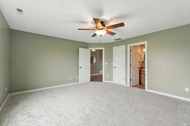 1328 Monte Carlo Dr, Huntertown, IN 46748 - unfurnished bedroom with carpet, baseboards, connected bathroom, and a ceiling fan