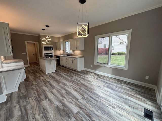 10403 Maple Springs Cv, Fort Wayne, IN 46845 - kitchen featuring appliances with stainless steel finishes, a sink, dark wood-type flooring, a center island, and white cabinetry