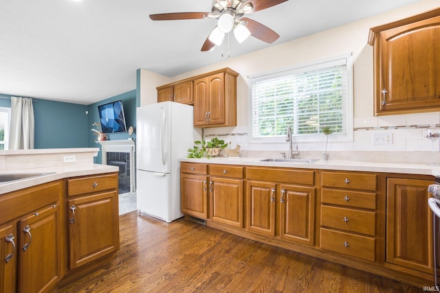 515 Cloudmont Dr, Osceola, IN 46561 - kitchen with a sink, freestanding refrigerator, a ceiling fan, brown cabinetry, and a tiled fireplace