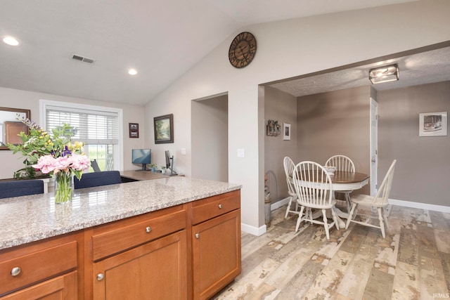 53722 Bittersweet Rd, Mishawaka, IN 46545 - kitchen with light wood-style flooring, vaulted ceiling, recessed lighting, baseboards, and light stone counters