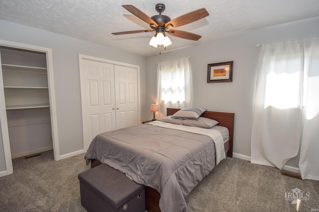 2318 W Concord Rd, Muncie, IN 47304 - bedroom with carpet, two closets, a textured ceiling, baseboards, and a ceiling fan