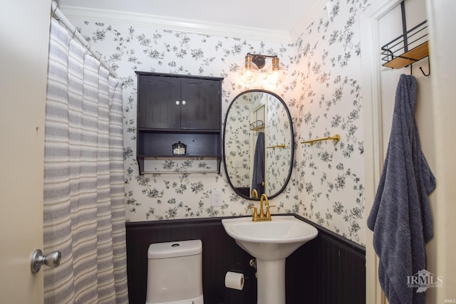 2318 W Concord Rd, Muncie, IN 47304 - bathroom featuring wallpapered walls, wainscoting, toilet, and ornamental molding