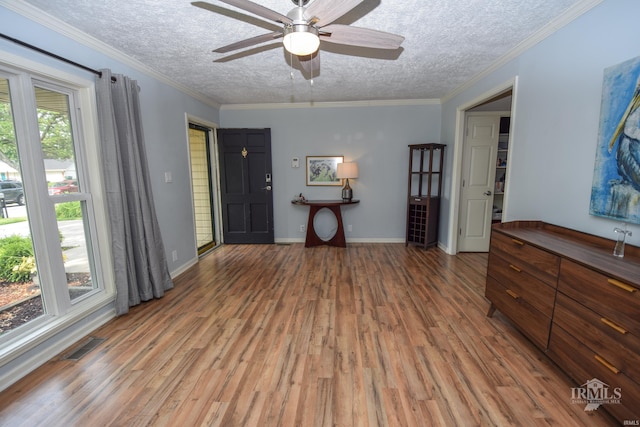2318 W Concord Rd, Muncie, IN 47304 - empty room with wood finished floors, a textured ceiling, ceiling fan, baseboards, and crown molding