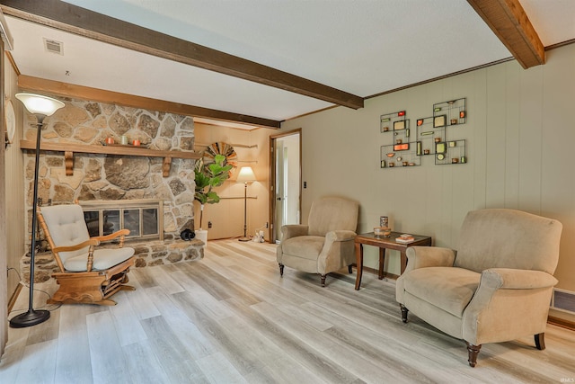 1402 Ivy Ct, North Manchester, IN 46962 - sitting room featuring beam ceiling, light wood-type flooring, and a stone fireplace
