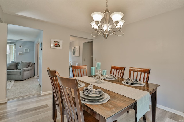 1402 Ivy Ct, North Manchester, IN 46962 - dining space featuring light wood finished floors, a chandelier, and baseboards