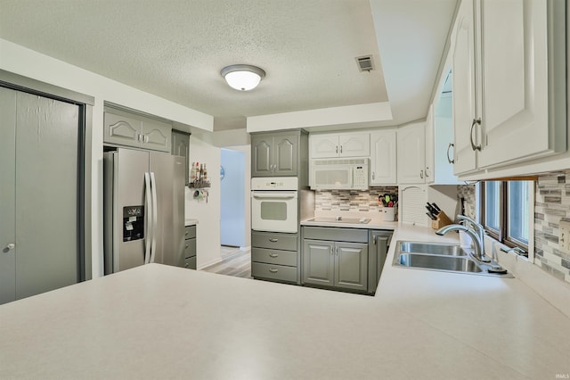 1402 Ivy Ct, North Manchester, IN 46962 - kitchen featuring white appliances, a sink, gray cabinets, tasteful backsplash, and light countertops