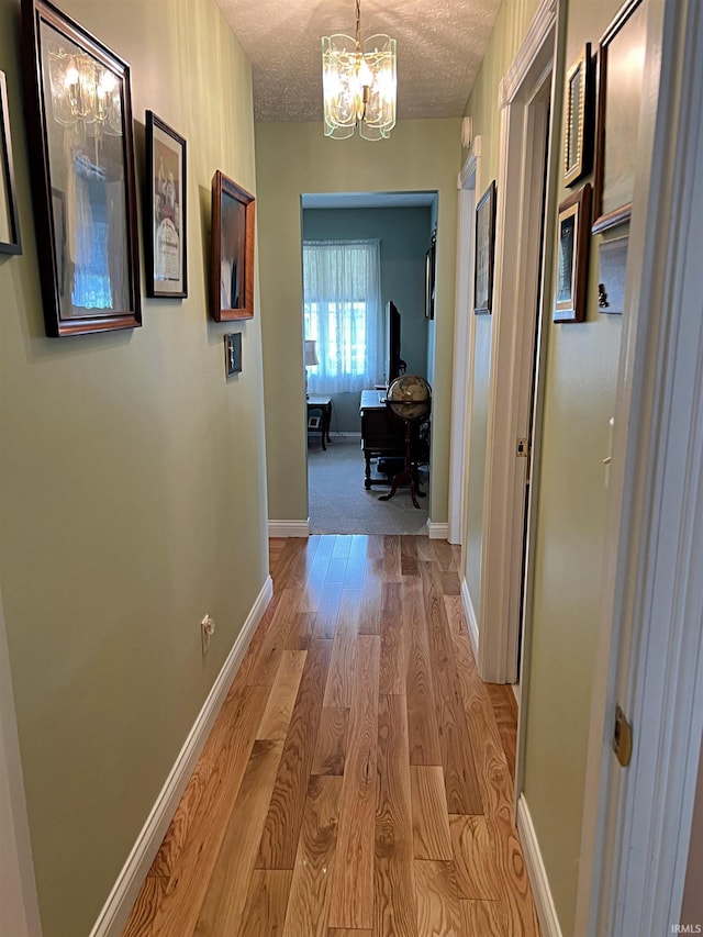 1976 Oak St, Linton, IN 47441 - corridor with light wood-type flooring, a chandelier, a textured ceiling, an office area, and baseboards