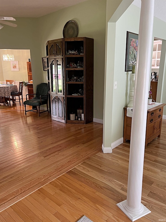 1976 Oak St, Linton, IN 47441 - hall with decorative columns, light wood finished floors, a chandelier, and baseboards