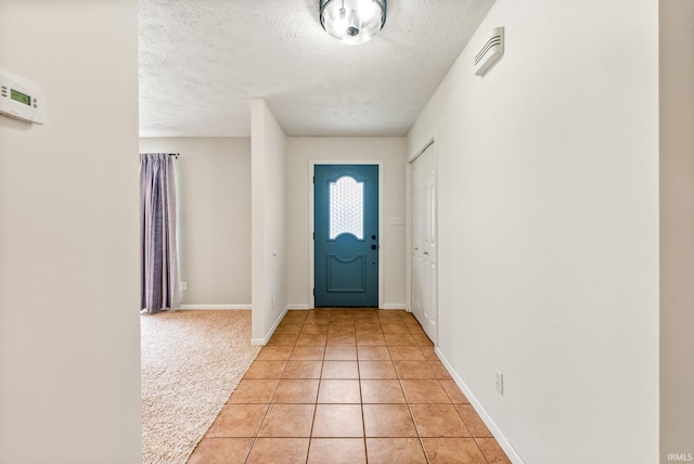 722 Biscayne Ave, Warsaw, IN 46580 - foyer featuring a textured ceiling, light tile patterned flooring, baseboards, and light carpet