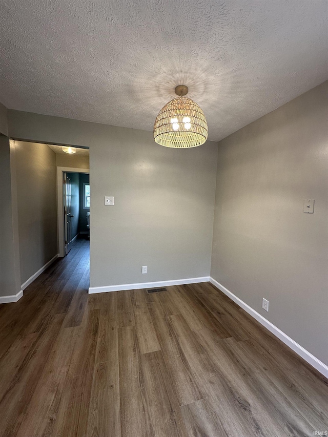 360 NE C St, Linton, IN 47441 - unfurnished room featuring dark wood-type flooring, baseboards, a chandelier, and a textured ceiling
