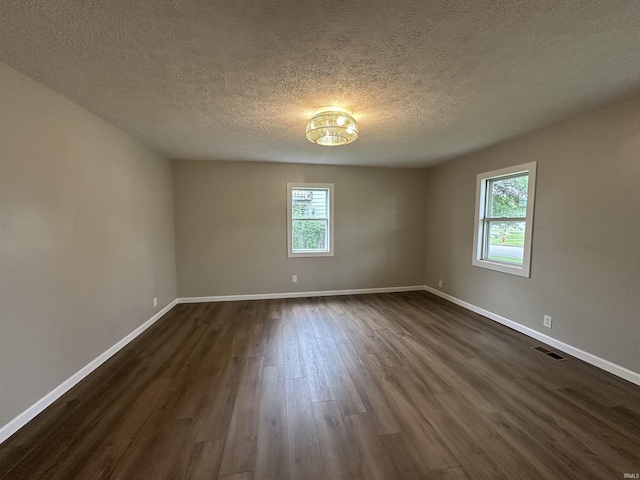 360 NE C St, Linton, IN 47441 - empty room with healthy amount of natural light, dark wood finished floors, baseboards, and a textured ceiling