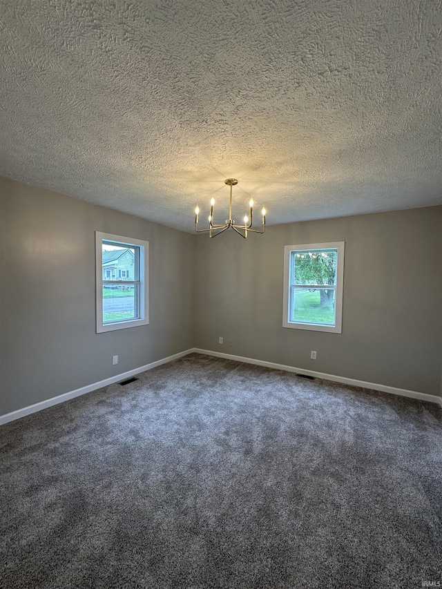 360 NE C St, Linton, IN 47441 - unfurnished room featuring plenty of natural light, a chandelier, dark carpet, baseboards, and a textured ceiling