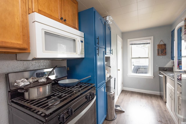 1310 Sinton Ave, Lafayette, IN 47905 - kitchen featuring appliances with stainless steel finishes, blue cabinetry, light wood-style floors, and baseboards