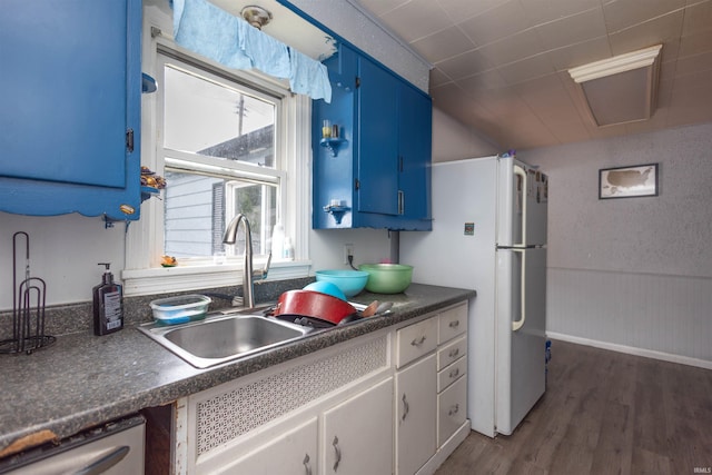 1310 Sinton Ave, Lafayette, IN 47905 - kitchen featuring blue cabinets, dark countertops, a sink, dark wood finished floors, and stainless steel dishwasher