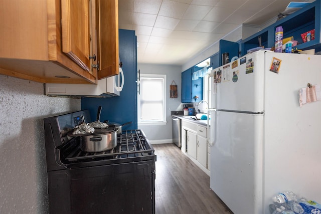 1310 Sinton Ave, Lafayette, IN 47905 - kitchen with freestanding refrigerator, black range oven, a sink, dishwasher, and brown cabinetry