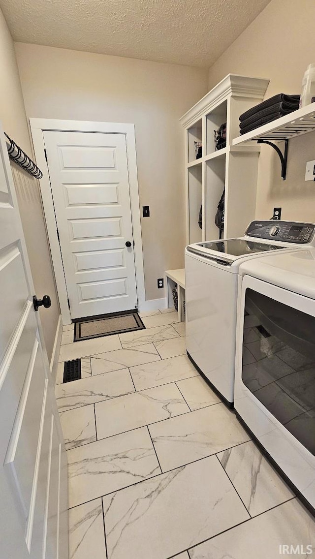 13224 Prairie Dr, Evansville, IN 47725 - laundry area featuring independent washer and dryer, light marble finish flooring, a textured ceiling, and baseboards