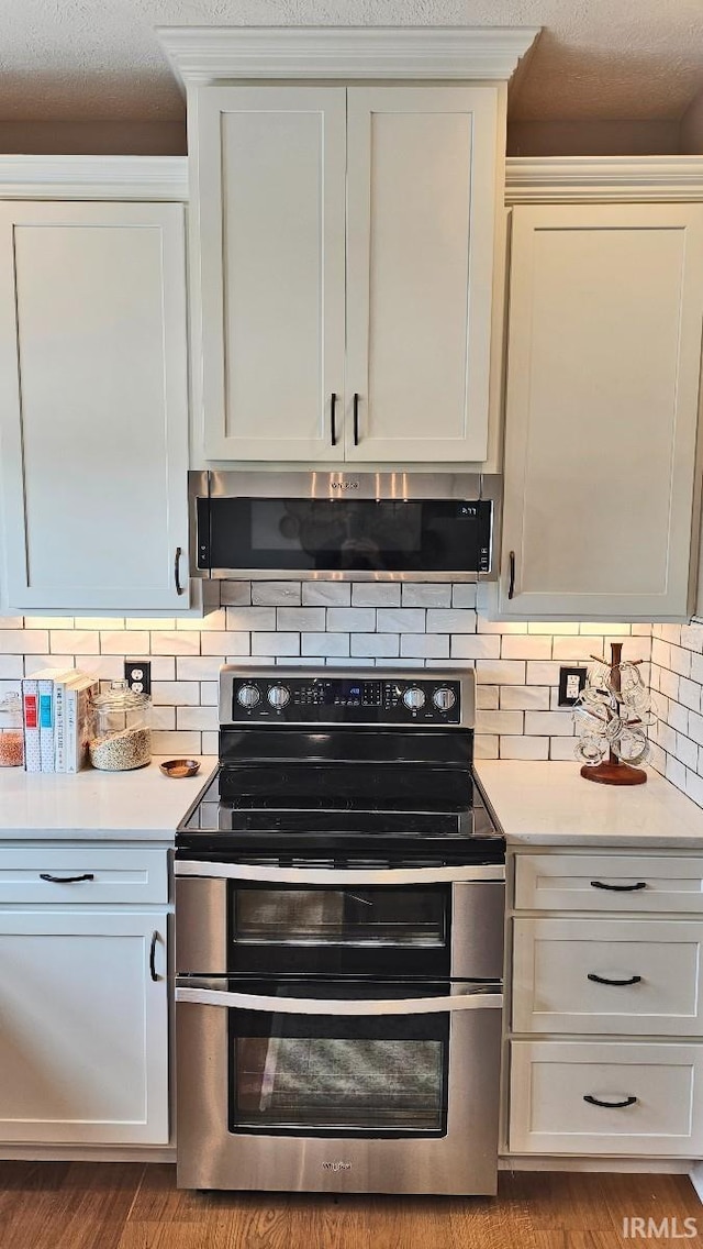 13224 Prairie Dr, Evansville, IN 47725 - kitchen with range with two ovens, range hood, light countertops, and tasteful backsplash