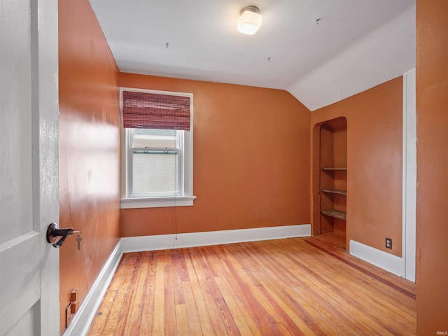 336 Arcadia Ct, Fort Wayne, IN 46807 - spare room featuring hardwood / wood-style flooring, baseboards, lofted ceiling, and built in shelves