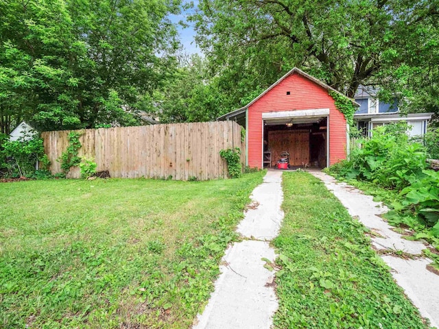336 Arcadia Ct, Fort Wayne, IN 46807 - view of yard featuring concrete driveway, a detached garage, and an outbuilding