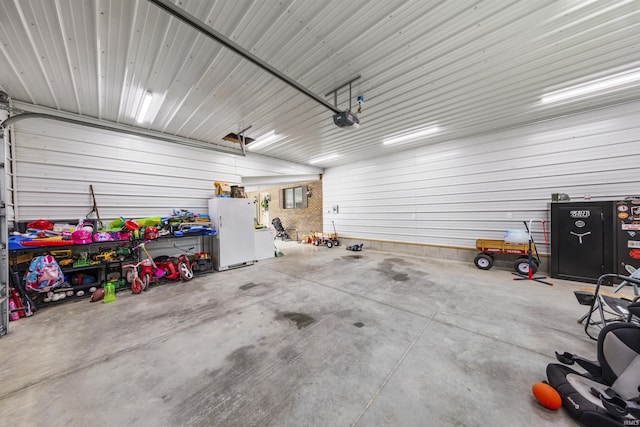 409 E Strain St, Fort Branch, IN 47648 - garage featuring a garage door opener and freestanding refrigerator