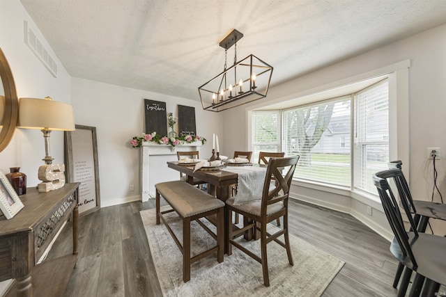 409 E Strain St, Fort Branch, IN 47648 - dining area with a textured ceiling, wood finished floors, a chandelier, and baseboards