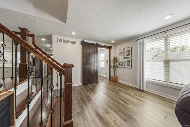 409 E Strain St, Fort Branch, IN 47648 - entryway with a barn door, a textured ceiling, stairway, wood finished floors, and baseboards