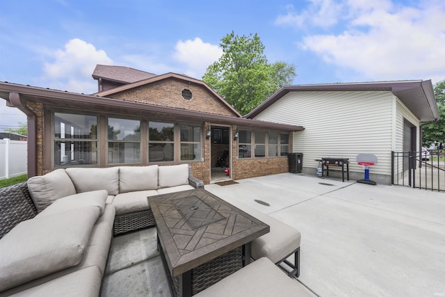 409 E Strain St, Fort Branch, IN 47648 - back of property featuring an outdoor living space, a patio, a sunroom, a garage, and brick siding