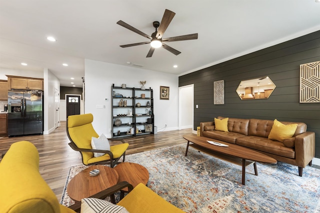 1215 Ladbrooke Dr, Evansville, IN 47725 - living room featuring light wood-style floors, a ceiling fan, recessed lighting, baseboards, and wooden walls