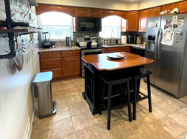 1741 Rockne Dr, South Bend, IN 46617 - kitchen with stainless steel appliances, tasteful backsplash, brown cabinetry, and butcher block countertops