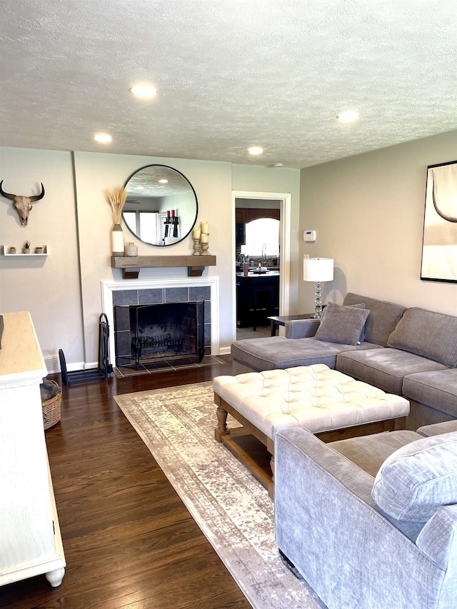 1741 Rockne Dr, South Bend, IN 46617 - living area featuring a textured ceiling, a tiled fireplace, recessed lighting, and dark wood-type flooring