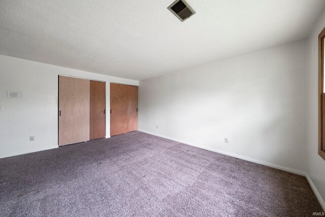 6320 Wakopa Ct, Fort Wayne, IN 46815 - unfurnished bedroom with two closets, dark colored carpet, baseboards, and a textured ceiling