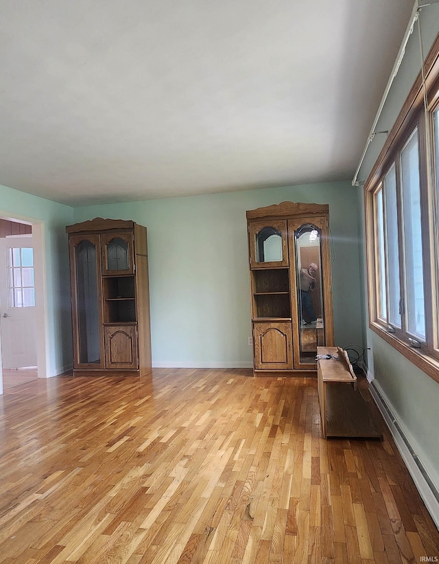 2703 Bosworth Dr, Fort Wayne, IN 46805 - unfurnished living room featuring light wood-style floors, baseboard heating, and baseboards