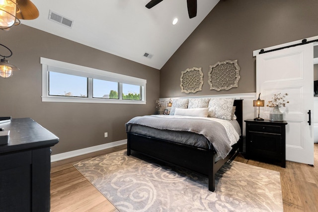 15306 Covington Rd, Fort Wayne, IN 46814 - bedroom featuring high vaulted ceiling, a barn door, light wood-style floors, ceiling fan, and baseboards