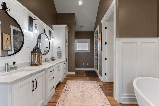 15306 Covington Rd, Fort Wayne, IN 46814 - bathroom featuring double vanity, a soaking tub, and wood finished floors