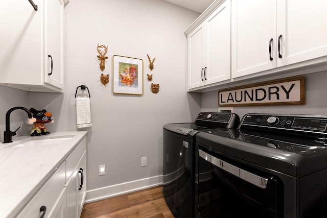 15306 Covington Rd, Fort Wayne, IN 46814 - laundry area with cabinet space, washing machine and clothes dryer, wood finished floors, and baseboards