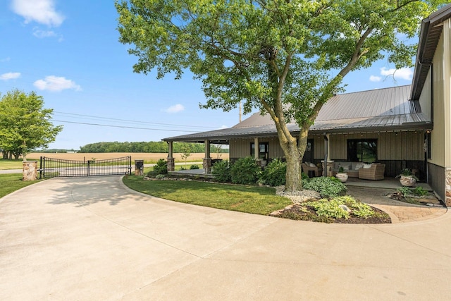 15306 Covington Rd, Fort Wayne, IN 46814 - view of front facade with outdoor lounge area, a gate, and metal roof
