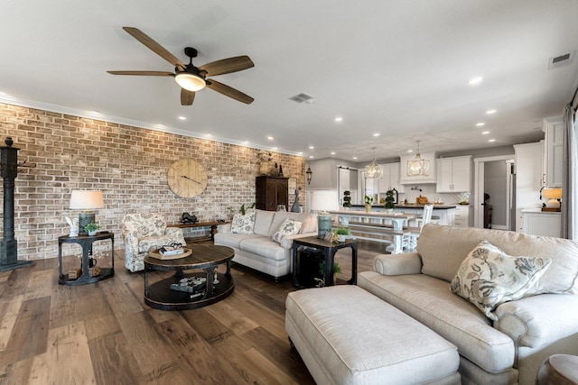 15306 Covington Rd, Fort Wayne, IN 46814 - living room featuring a ceiling fan, recessed lighting, dark wood-type flooring, a wood stove, and brick wall