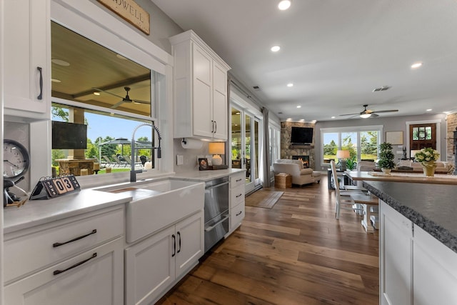 15306 Covington Rd, Fort Wayne, IN 46814 - kitchen featuring ceiling fan, a fireplace, a sink, recessed lighting, and white cabinetry
