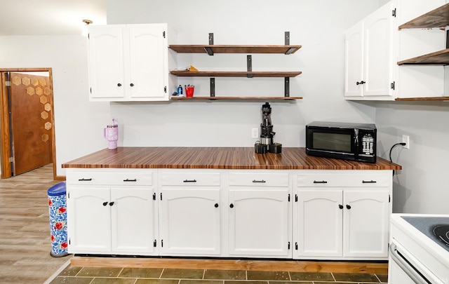 301 S Mccreary St, Fort Branch, IN 47648 - kitchen featuring open shelves, black microwave, white cabinets, and wood finished floors