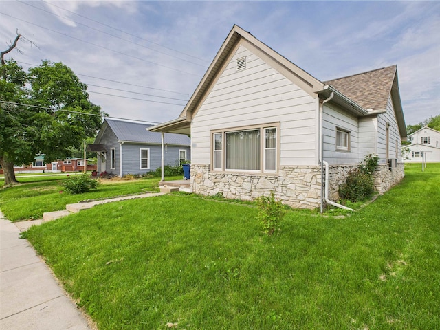 63 S Market St, Andrews, IN 46702 - view of front of house with stone siding, roof with shingles, and a front yard