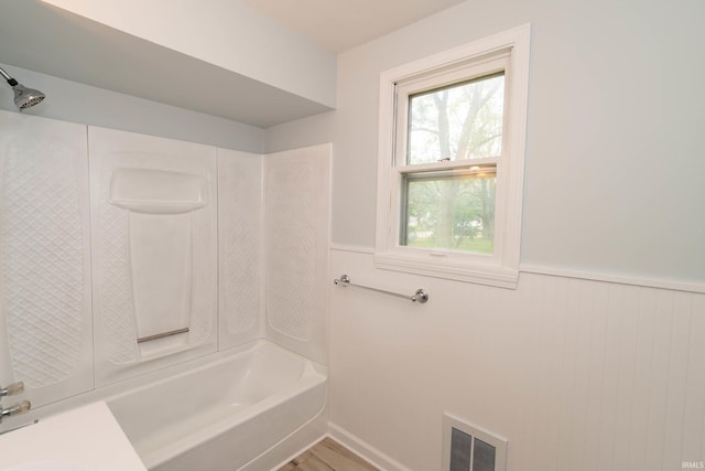 1307 Cassopolis St, Elkhart, IN 46514 - bathroom featuring a wainscoted wall, bathing tub / shower combination, and wood finished floors
