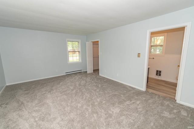 1307 Cassopolis St, Elkhart, IN 46514 - unfurnished bedroom featuring a baseboard radiator, multiple windows, carpet floors, and baseboards