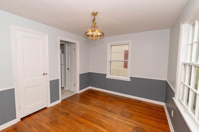 1307 Cassopolis St, Elkhart, IN 46514 - unfurnished room with a chandelier, wood finished floors, wainscoting, and baseboards