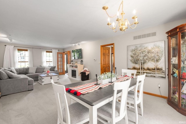 58679 Baugo Xing, Elkhart, IN 46517 - dining room with light carpet, a chandelier, and a glass covered fireplace