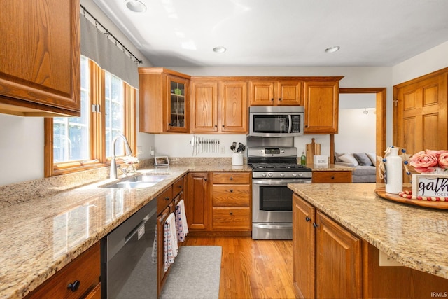 58679 Baugo Xing, Elkhart, IN 46517 - kitchen with stainless steel appliances, brown cabinets, light stone counters, light wood-style floors, and recessed lighting