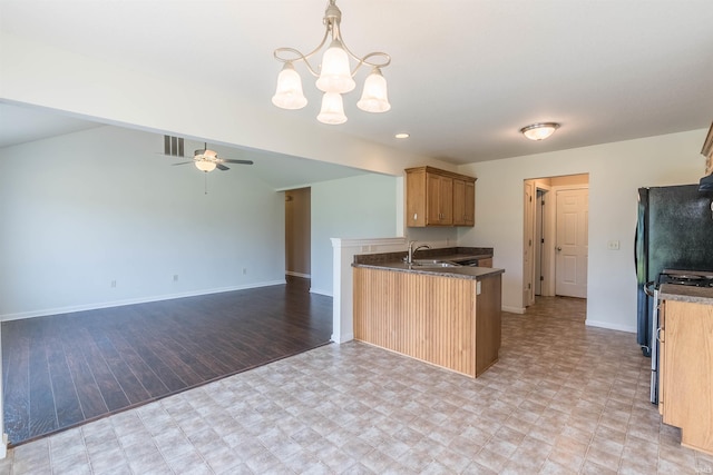 2502 Trillium Cv, Huntertown, IN 46748 - kitchen with a chandelier, a ceiling fan, a peninsula, baseboards, and stainless steel range