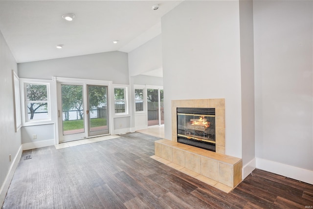 618 N Lake St, Warsaw, IN 46580 - unfurnished living room with wood finished floors, a tile fireplace, baseboards, high vaulted ceiling, and recessed lighting