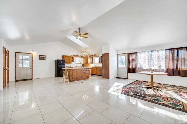 4627 E 100th Hwy N, Monticello, IN 47960 - kitchen with freestanding refrigerator, vaulted ceiling, a center island, plenty of natural light, and light countertops